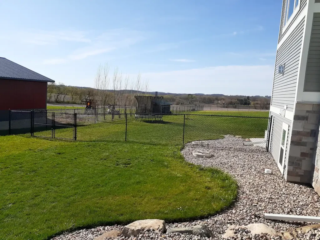 Black vinyl chain link fence with rocked landscaping